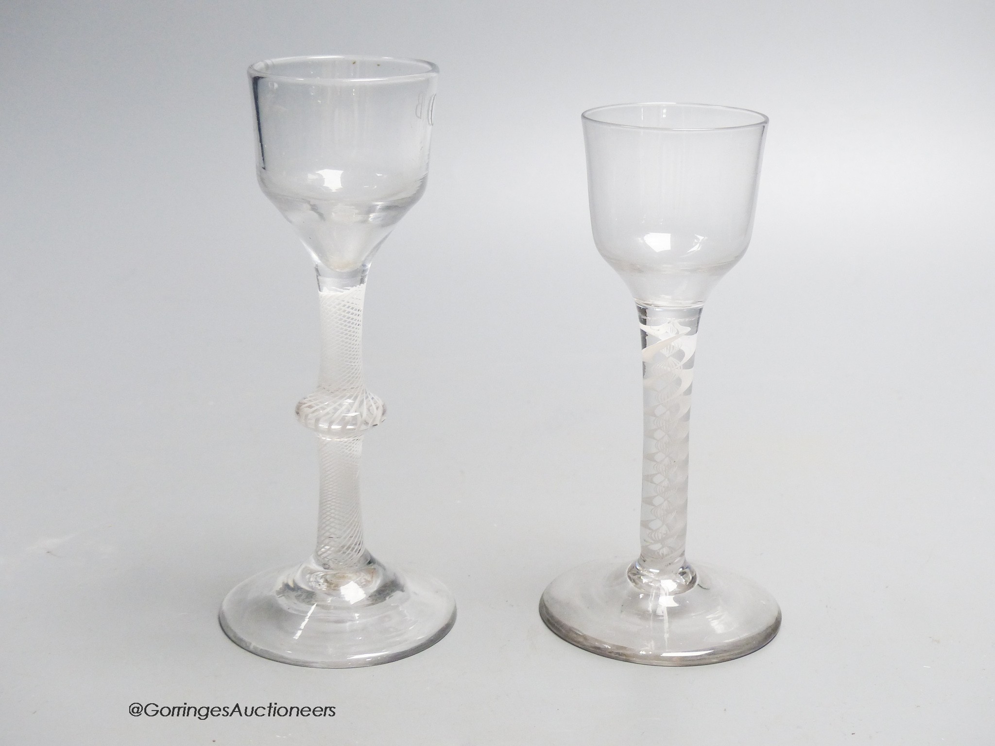 Two Georgian opaque twist stem cordial glasses, each with a funnel bowl, one engraved C B with dove and olive branch, tallest 15cm